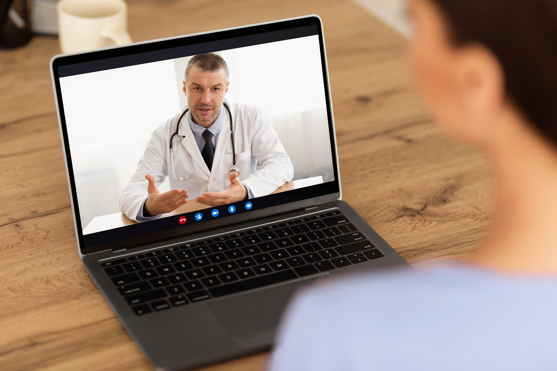Woman having video chat with doctor on laptop at home