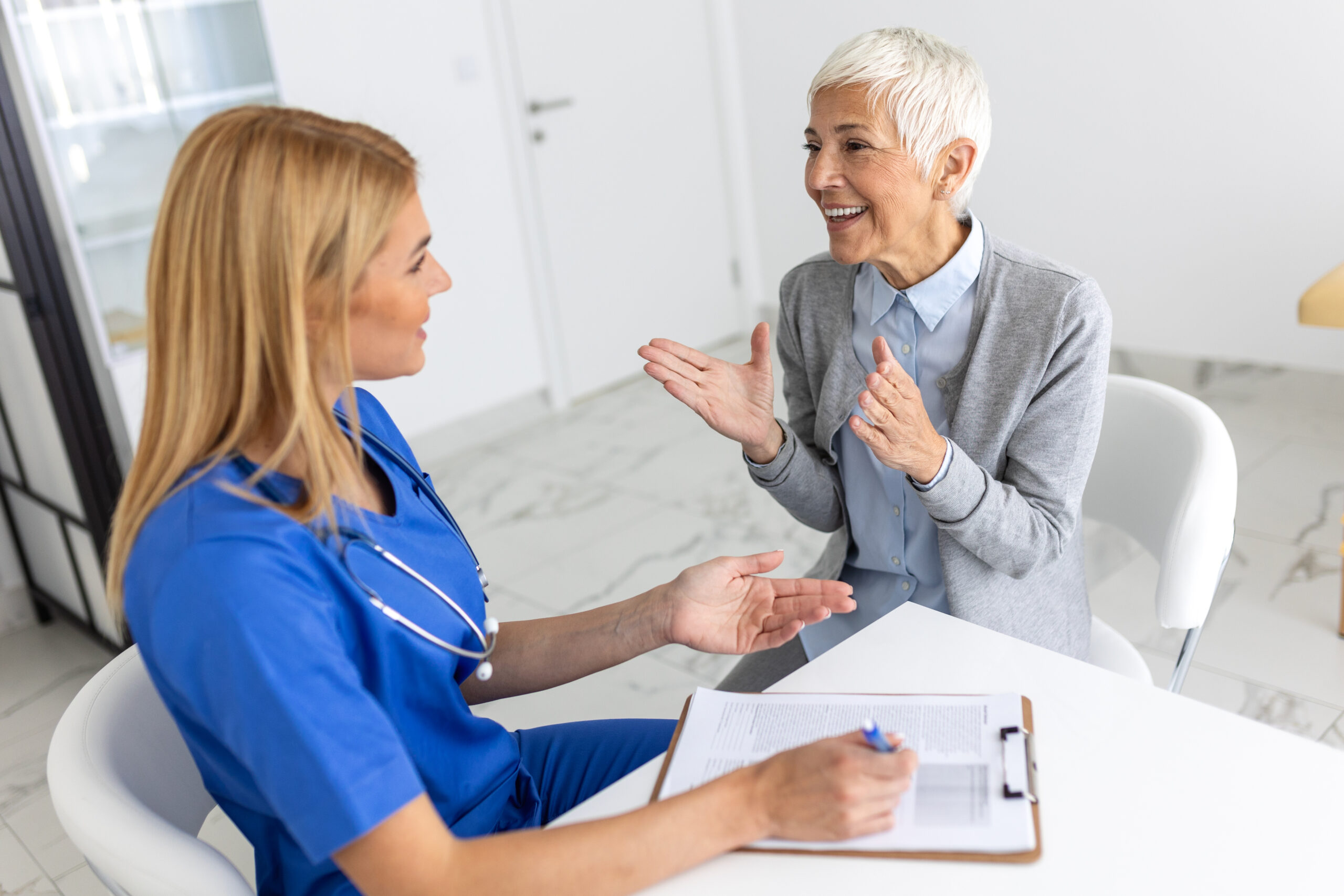 Senior woman, doctor and elderly patient with good news, tablet and results for health, advice and report. Happy medic, clipboard with smile, tech or support in hospital PET/CT scan